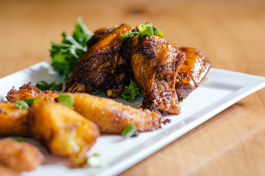 An appetizer of jerk chicken wings and fried plantains. (Photo by Kathy Tran)