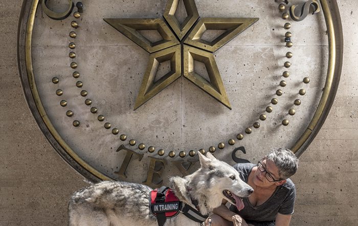 Fran Gaconnier and her dog in front of City of Dallas sign.