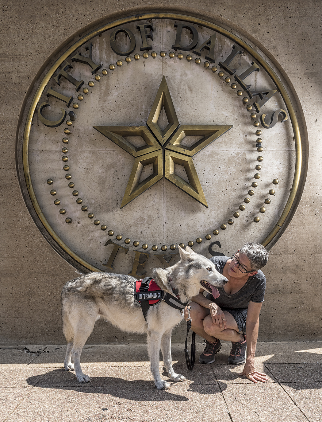 Fran Gaconnier and her dog in front of City of Dallas sign.