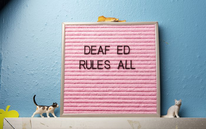 Sign in classroom that reads "Deaf Ed Rules All"