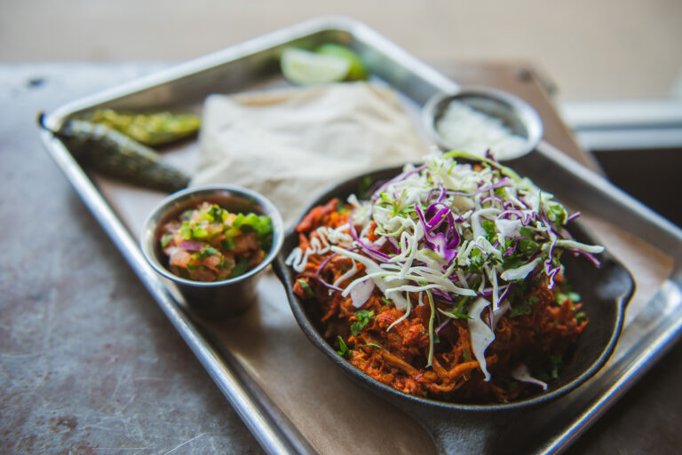 Braised pork tacos are served with blue corn tortillas and topped with slaw. Henry’s Majestic. Photography by Lauren Allen